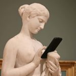 Eine Statue mit einem Smartphone zum Beitrag: So schützen Sie das Telefon vor Beschädigungen