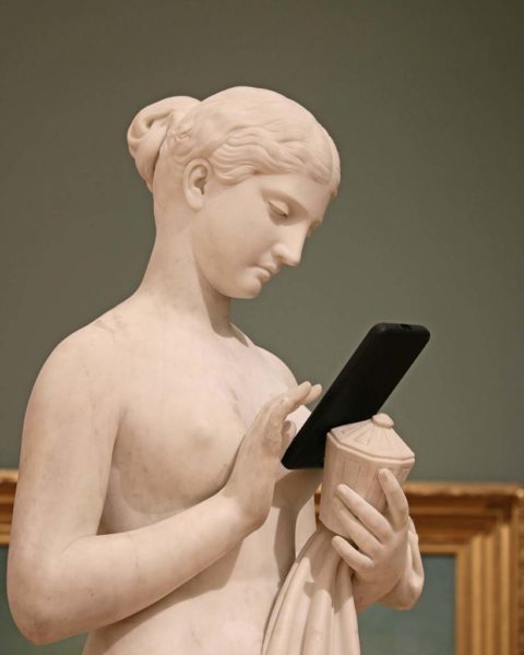 Eine Statue mit einem Smartphone zum Beitrag: So schützen Sie das Telefon vor Beschädigungen